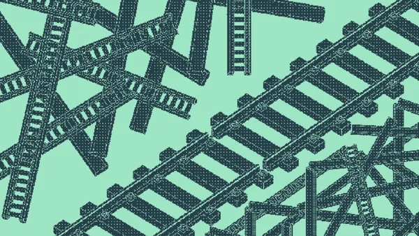 Railroad track segments in a chaotic crisscross beside straight parallel lines