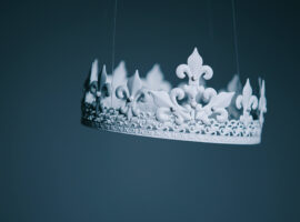 White crown hanging in front of blue background