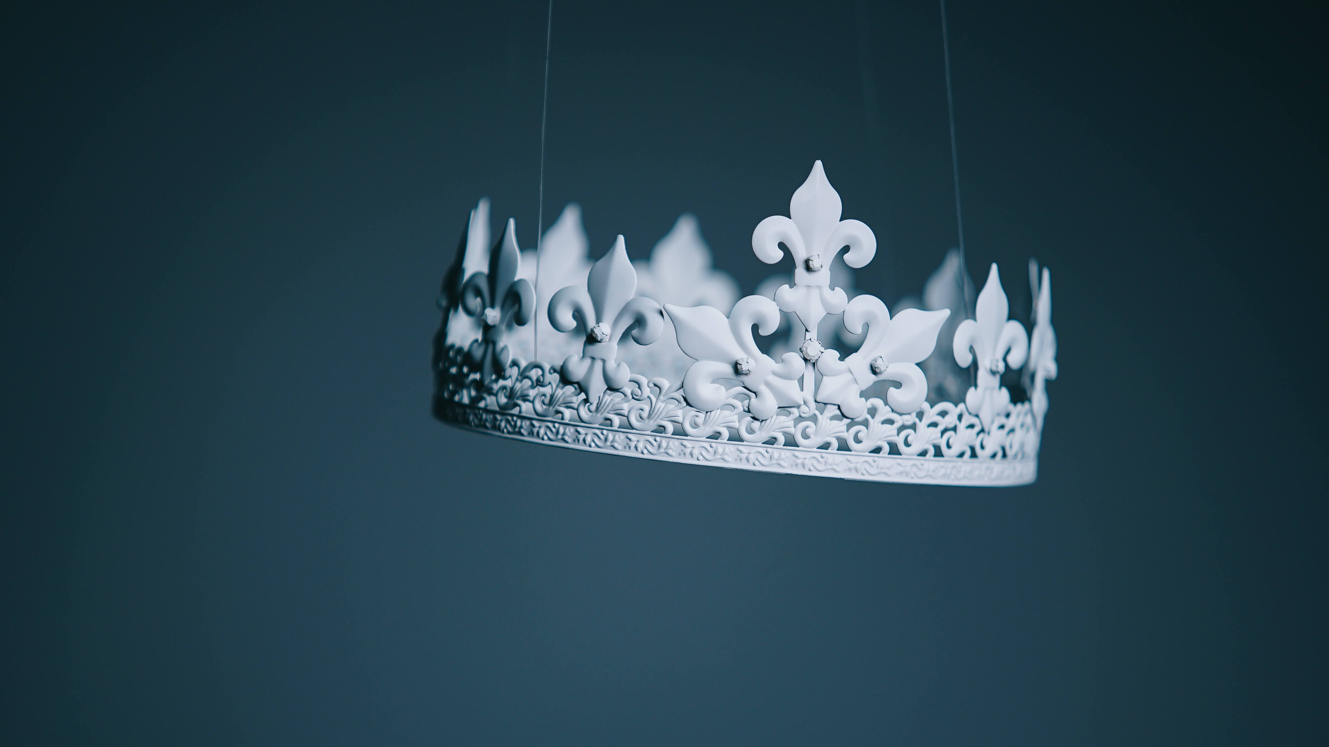 White crown hanging in front of blue background