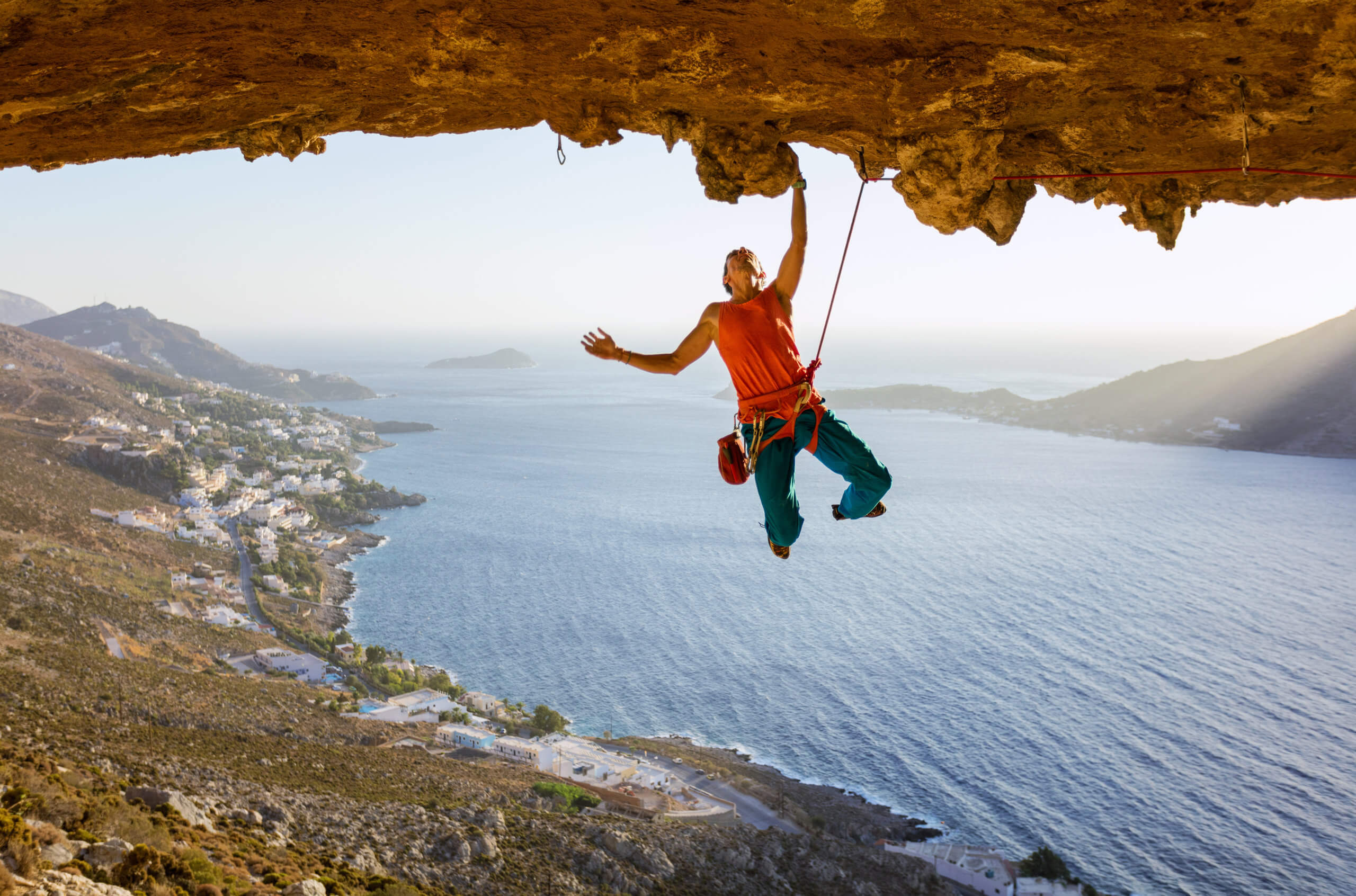 Male rock climber on challenging route going along ceiling in ca